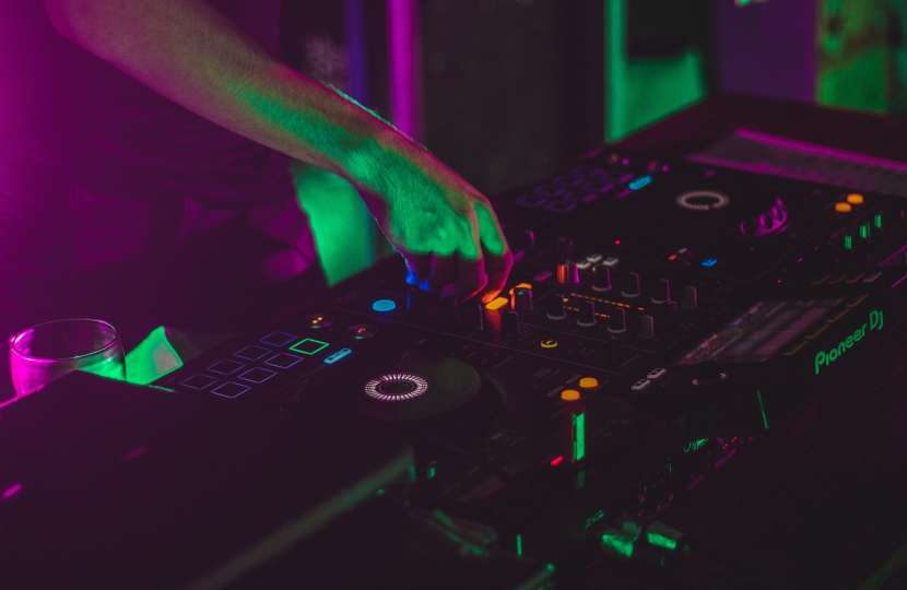 person playing dj controller in a dark room