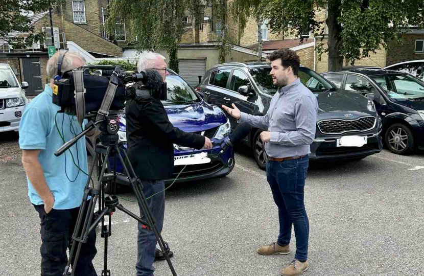 Elliot speaking to members of the press about his campaign calling on the Council to reverse its decision on parking charges.